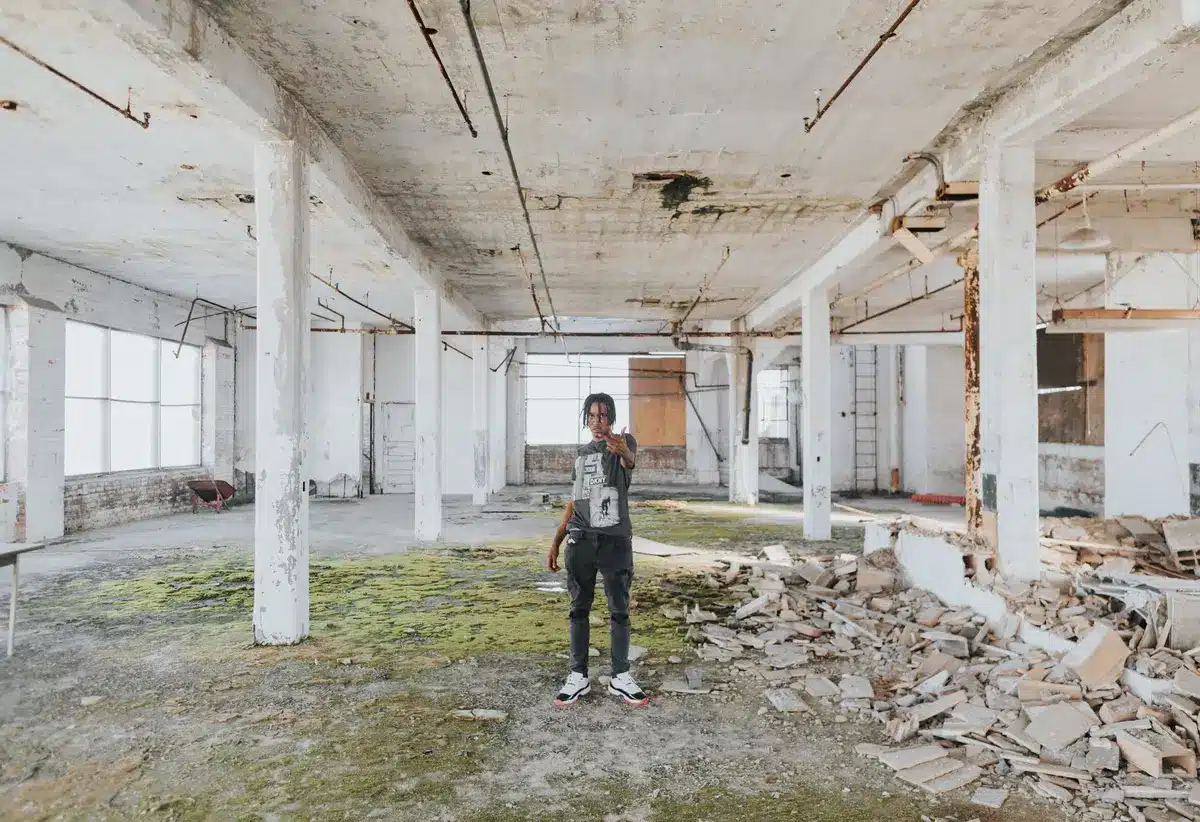Gritty 1970s urban warehouse setting with concrete walls and industrial atmosphere