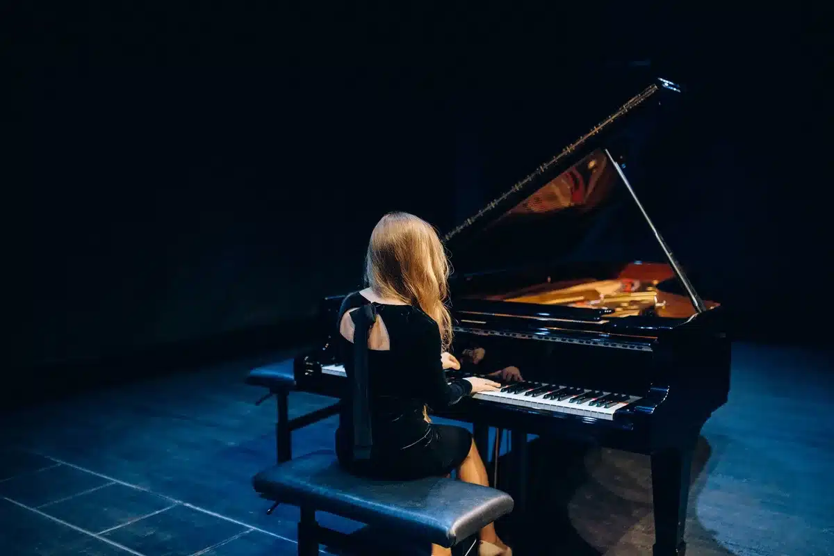 Avant-garde pianist performing at a grand piano in a secluded setting