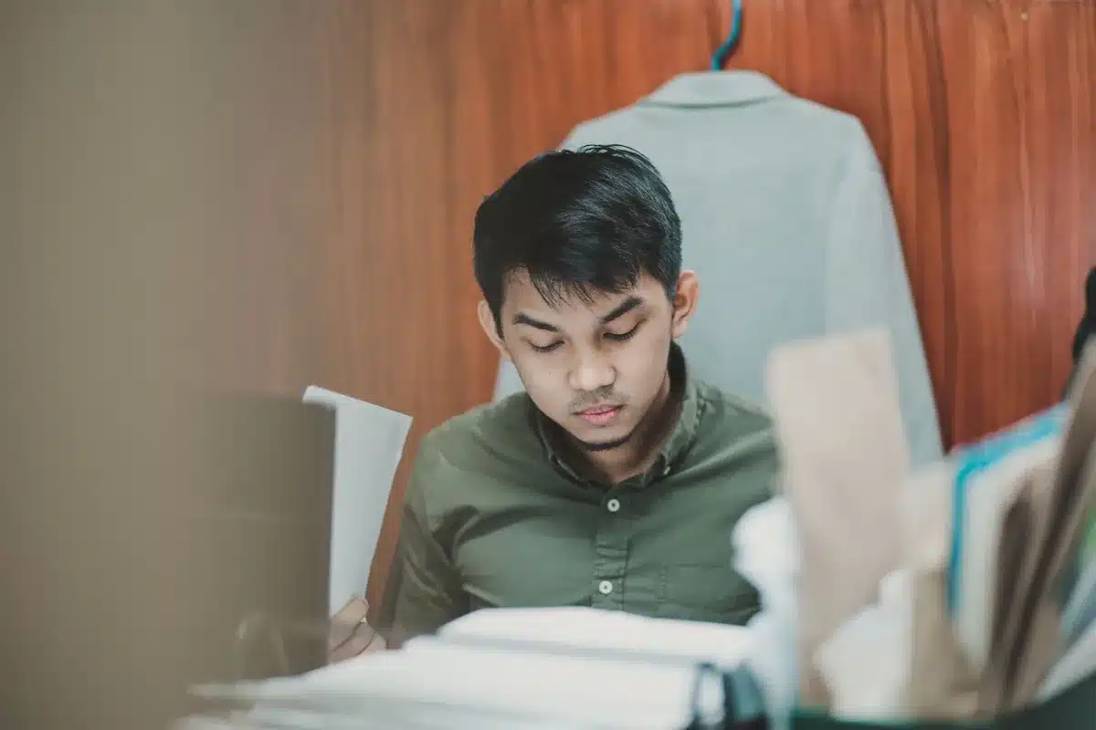 Anonymous office workers focused on tasks at desks in a busy workplace environment
