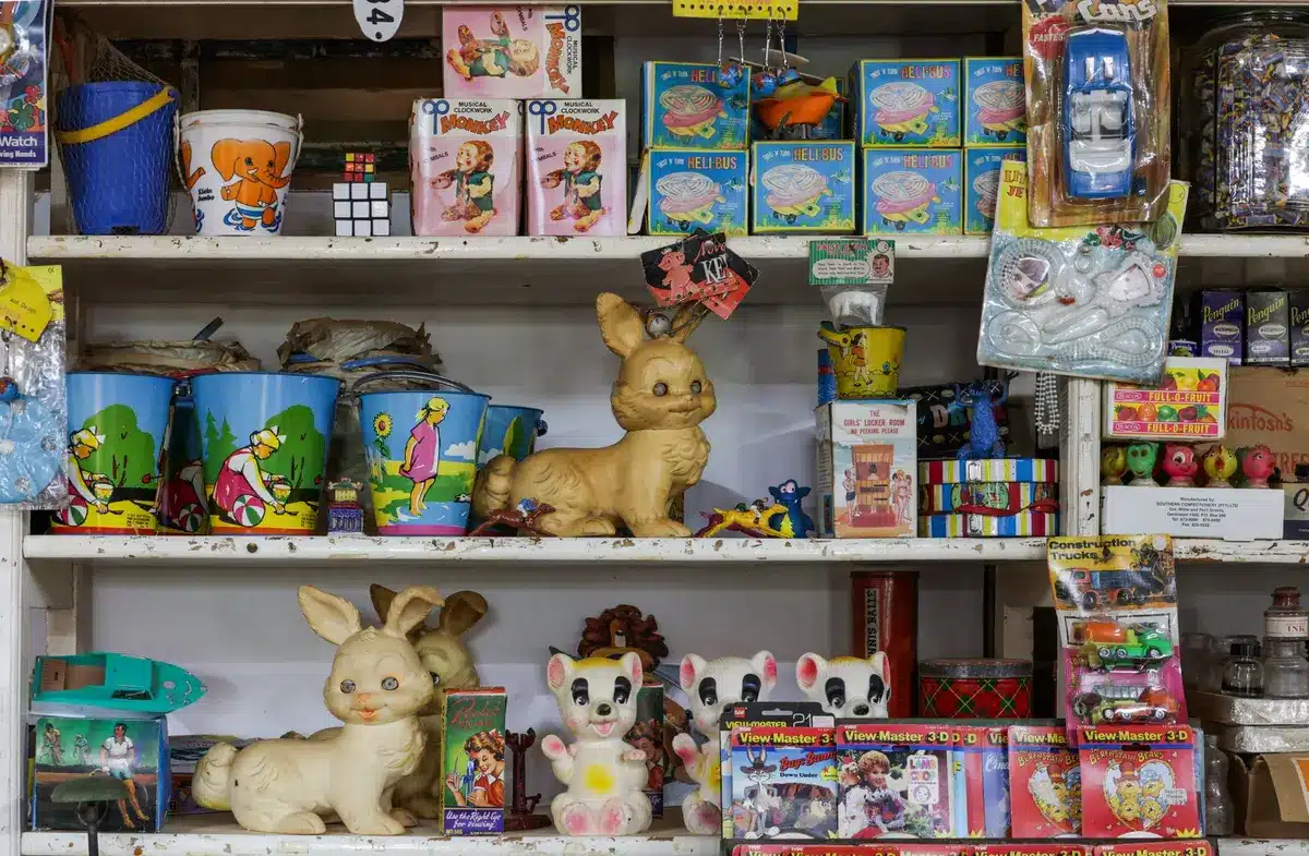 Porcelain doll in dusty attic surrounded by old toys and memories