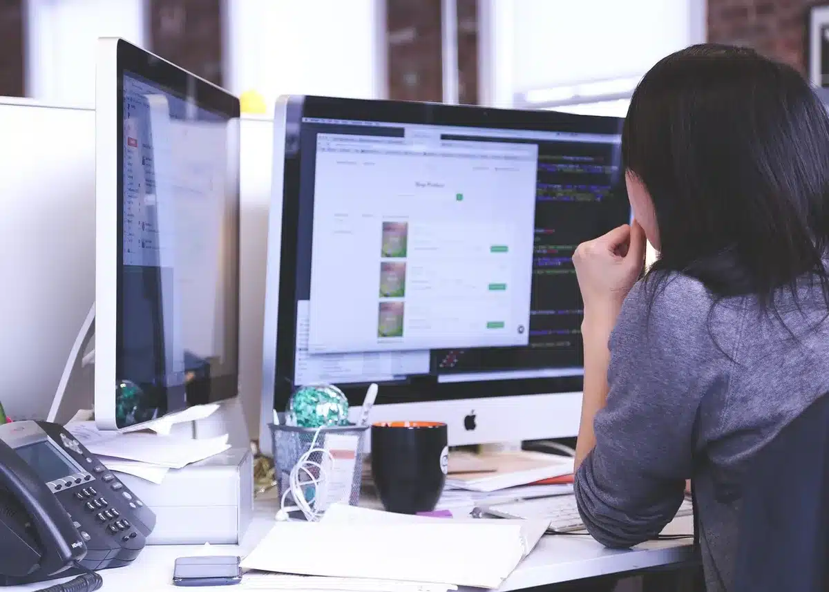Person at a desk sending an email or professional message on a laptop.