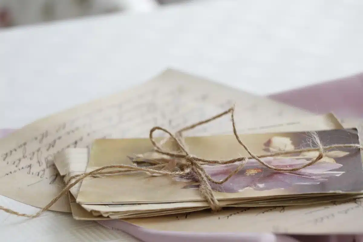 A mailbox and handwritten letters beside an old house evoking time-crossed romance