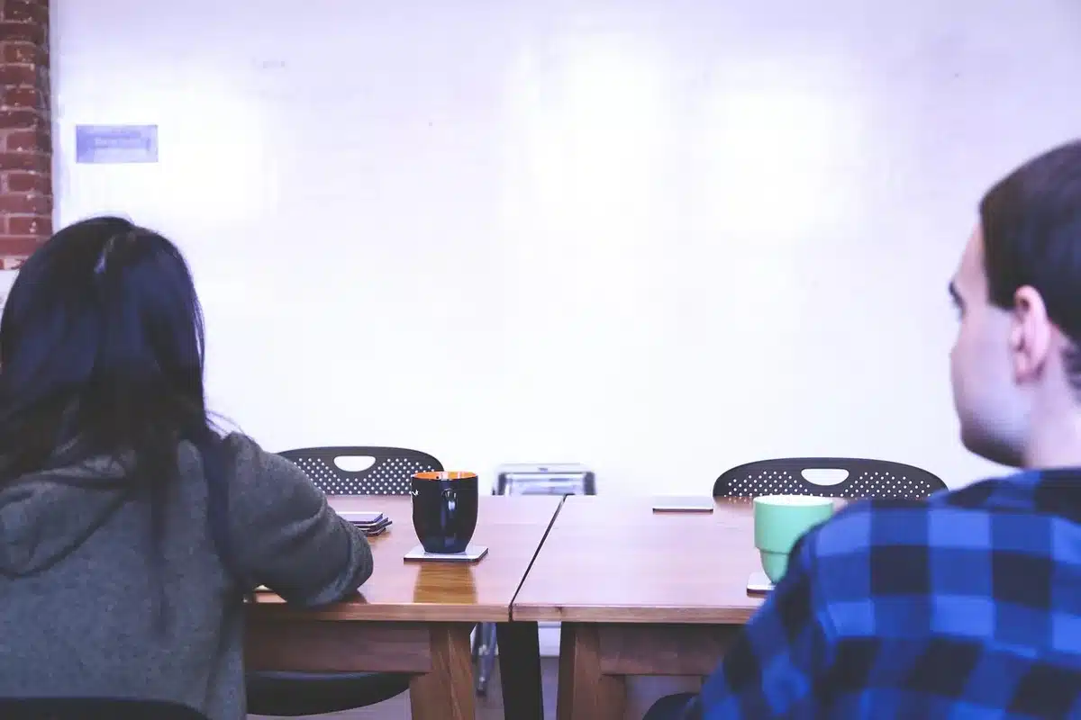 Marketing team members in a meeting, some engaged and others distracted, illustrating communication challenges in larger