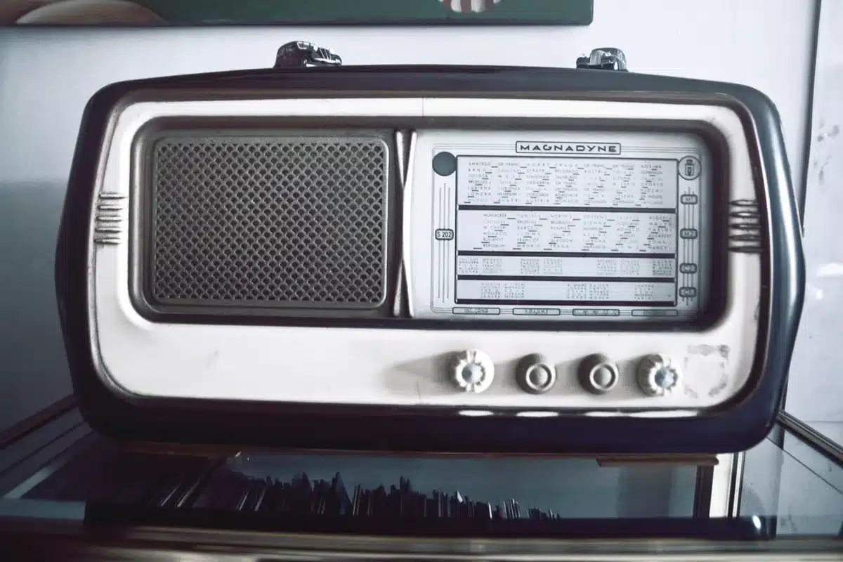 Anonymous group around a vintage radio and suitcase on a wartime street, silhouetted