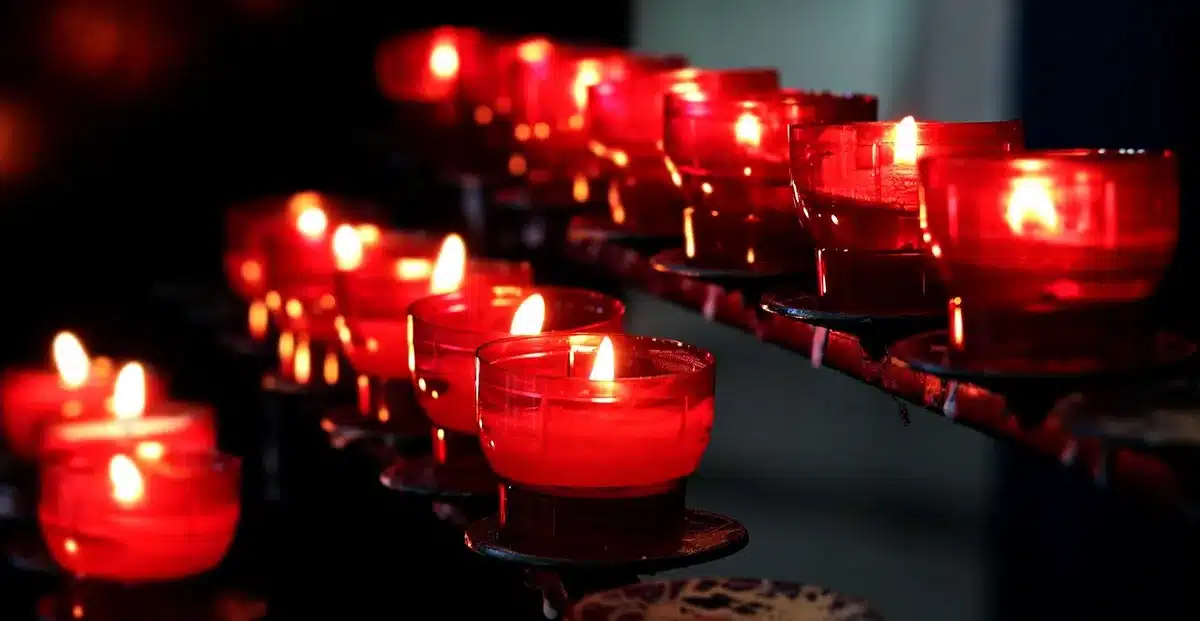 Silhouette by candlelight with crucifix and old book on a church table