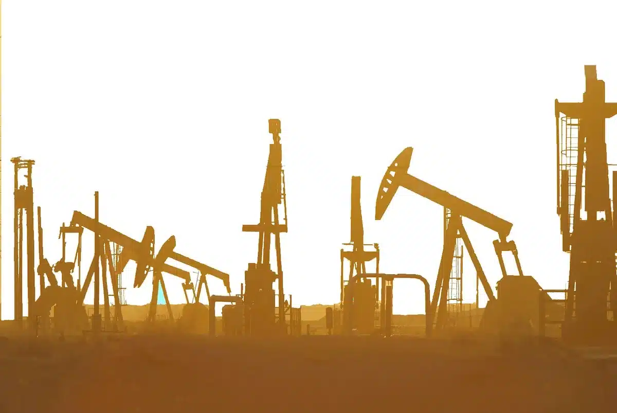 Silhouette of a suited figure on an oil rig platform under an overcast sky